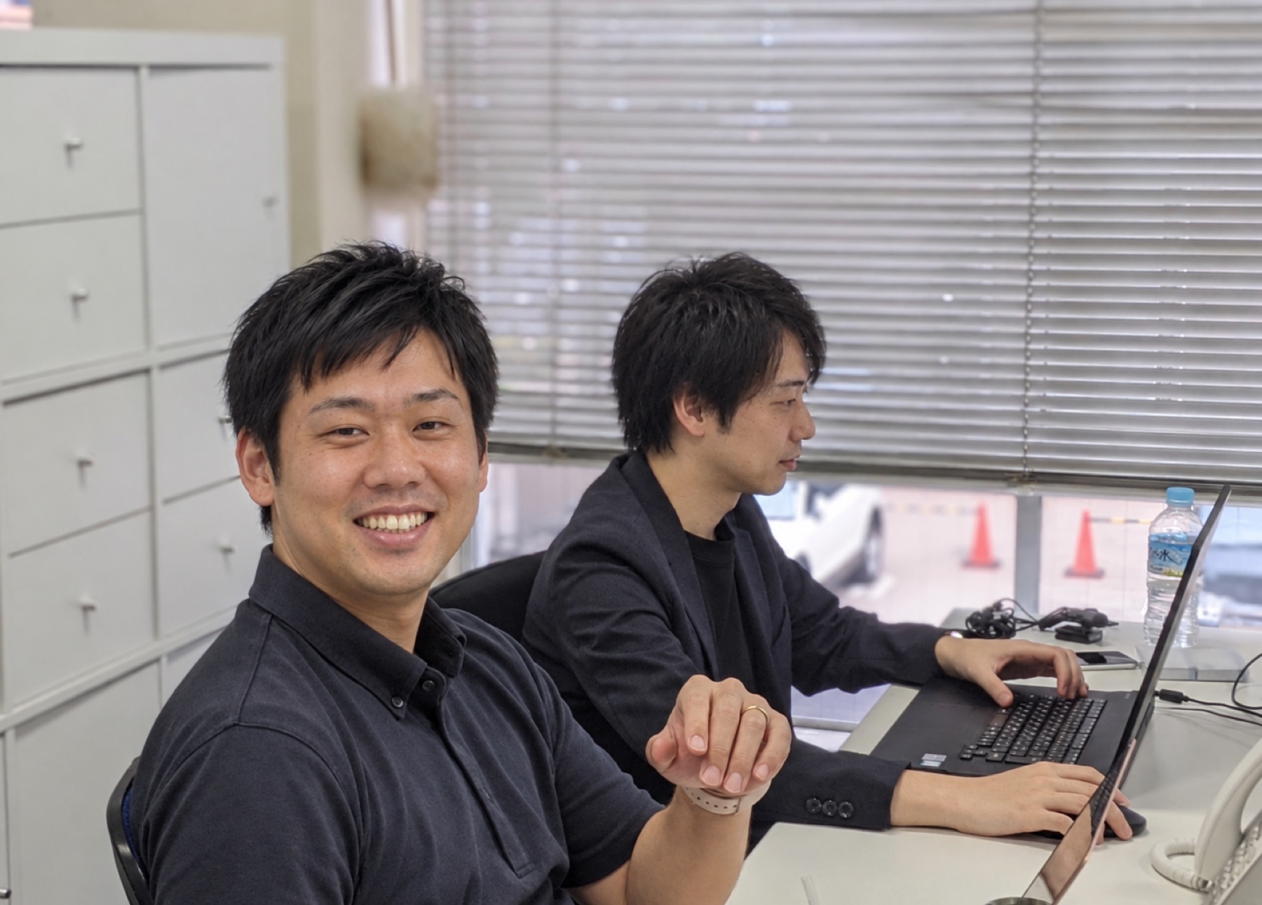 オフィスでパソコンに向かう二人のメンバーのイメージ